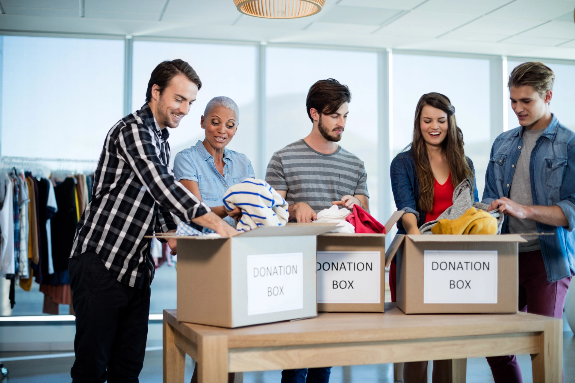 Creative business team sorting clothes in donation box